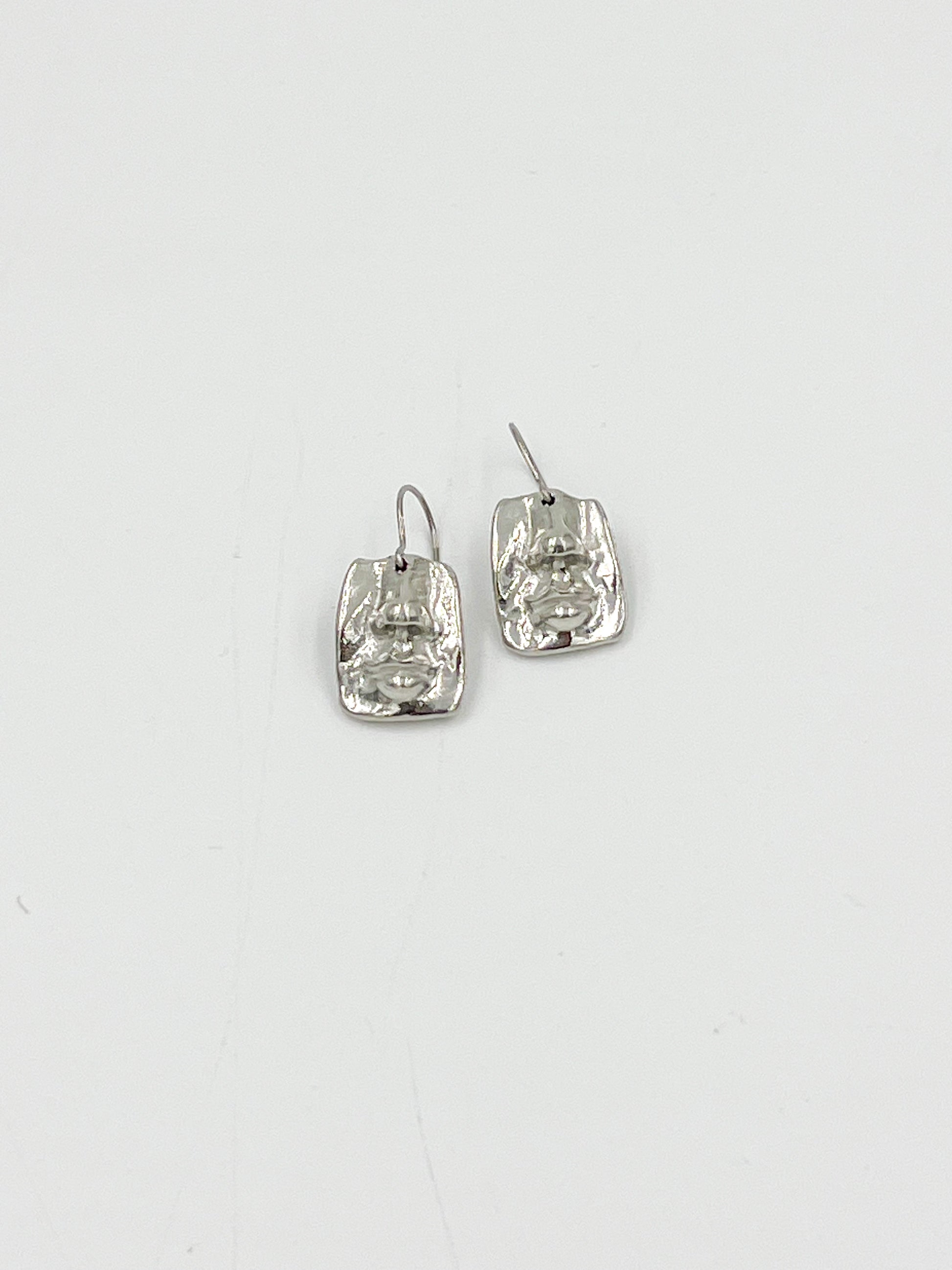 Looking for a funky and lighthearted addition to your jewelry collection? Look no further than our Face Earrings! Made with surgical steel and lead and nickel free pewter findings, these earrings are sure to be both safe and stylish. With a highly polished finish and measuring at 3/4 inches, these are perfect for adding a touch of fun and whimsy to any outfit.