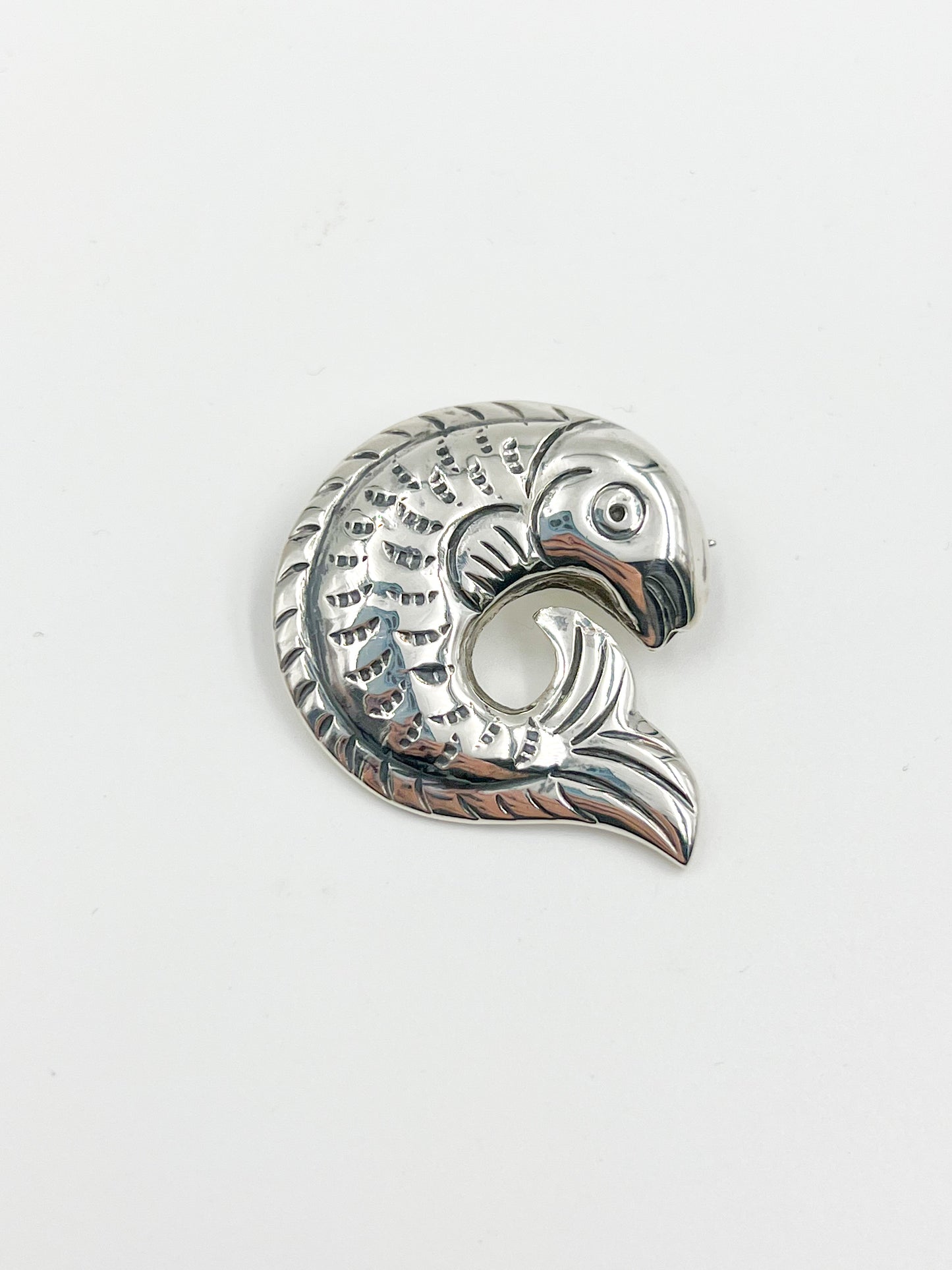 Introducing the Spratling Silver Fish Pin! This unique design is made of sterling silver and features the iconic fish motif. All pieces produced since 1979 by Sucesores de William Spratling sport the TS-24 Mexican registry mark and an authentic Spratling hallmark, adding to their value and charm. Please note that all pieces are handmade and may differ in size from the photo shown.