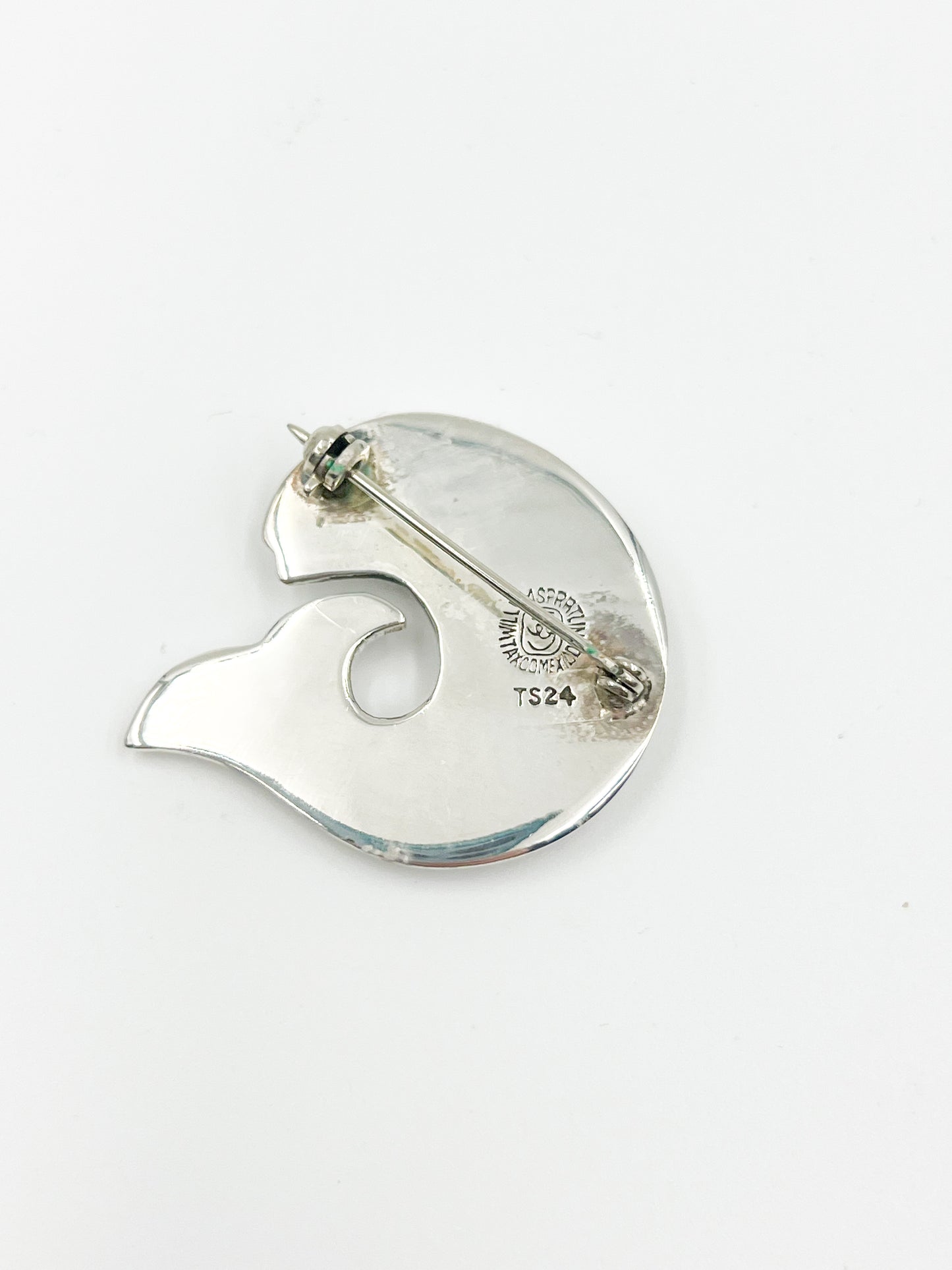 Introducing the Spratling Silver Fish Pin! This unique design is made of sterling silver and features the iconic fish motif. All pieces produced since 1979 by Sucesores de William Spratling sport the TS-24 Mexican registry mark and an authentic Spratling hallmark, adding to their value and charm. Please note that all pieces are handmade and may differ in size from the photo shown.