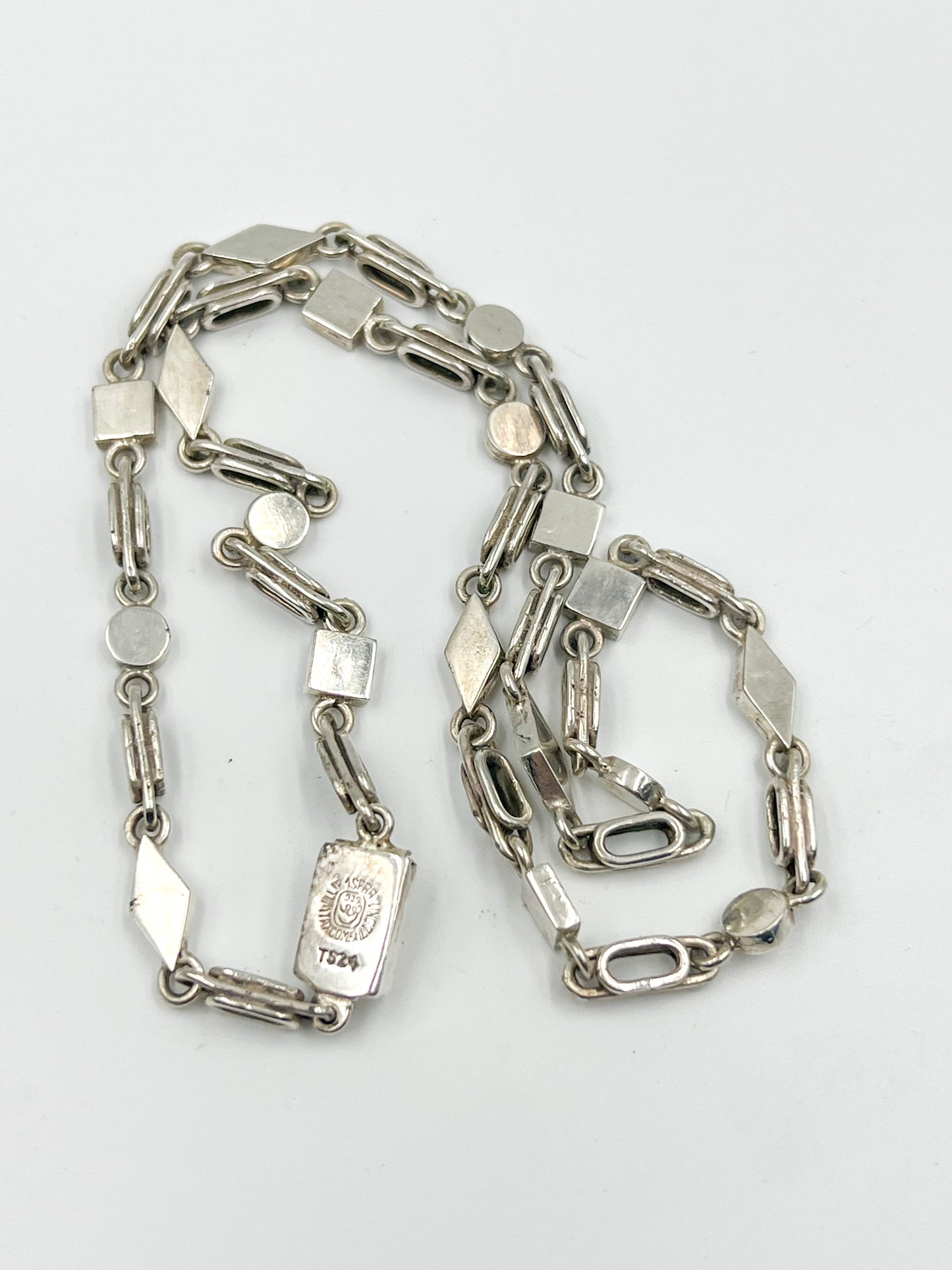 A handmade masterpiece! Featuring a playful clasp closure, this 16-18 (neck side depending) inch Spratling Silver Geometric Chain Necklace is a must-have. Complete with the iconic TS-24 Mexican registry mark and a replica of an older Spratling hallmark, every piece is unique and full of charm. Please note: sizes may vary slightly from the photo.