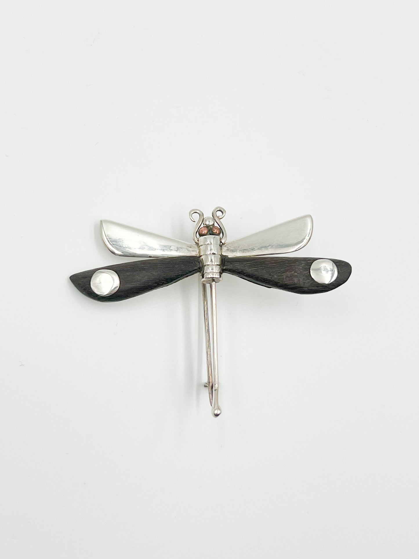 Spratling Silver and Ebony Dragonfly Pin Featuring durable black/brown Ebony wood and a playful dragonfly design, this pin is marked with the current Mexican registry mark TS-24 and an older Spratling hallmark. All items produced since 1979 by Sucesores de William Spratling are guaranteed to have these marks.