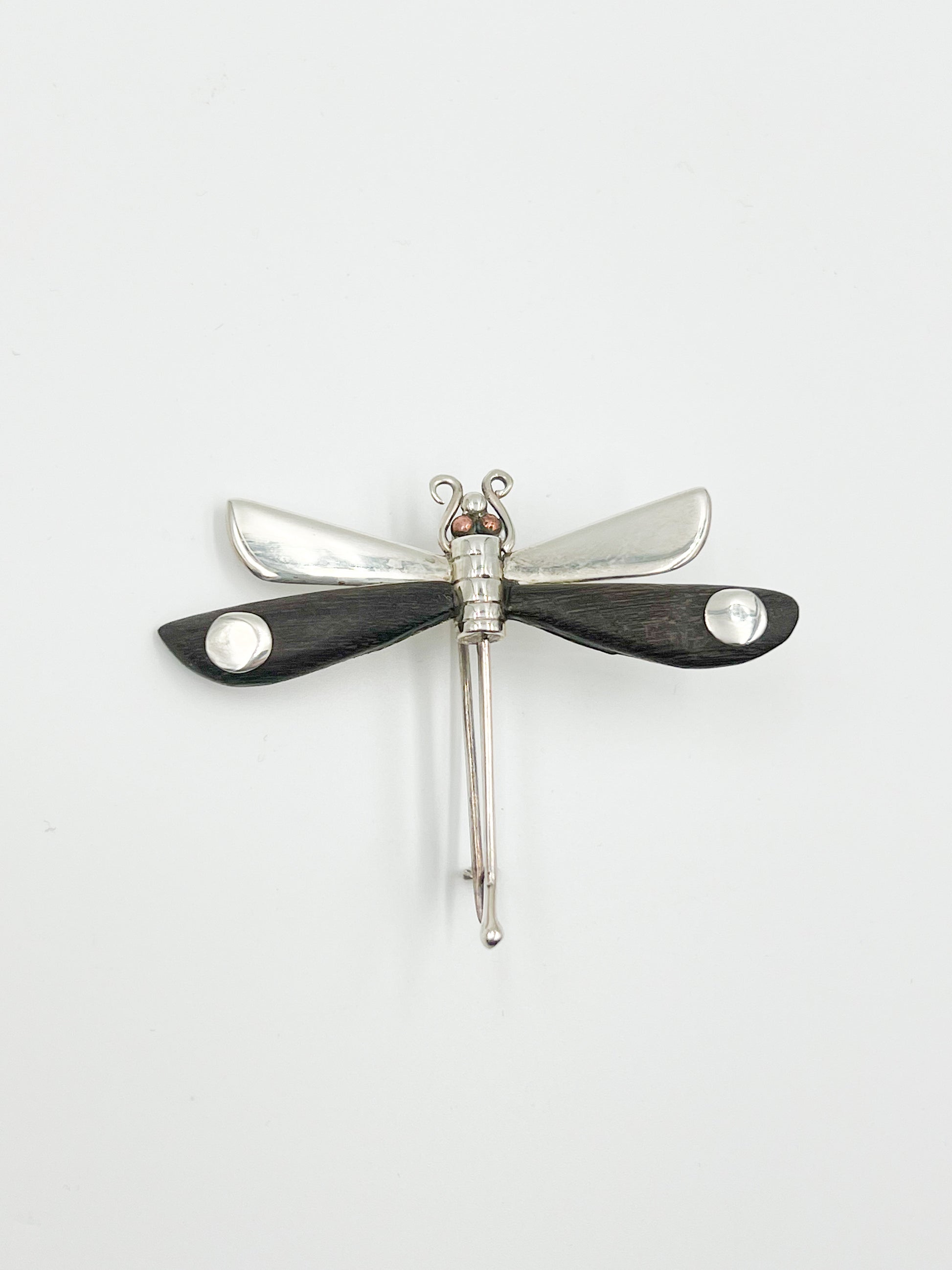 Spratling Silver and Ebony Dragonfly Pin Featuring durable black/brown Ebony wood and a playful dragonfly design, this pin is marked with the current Mexican registry mark TS-24 and an older Spratling hallmark. All items produced since 1979 by Sucesores de William Spratling are guaranteed to have these marks.