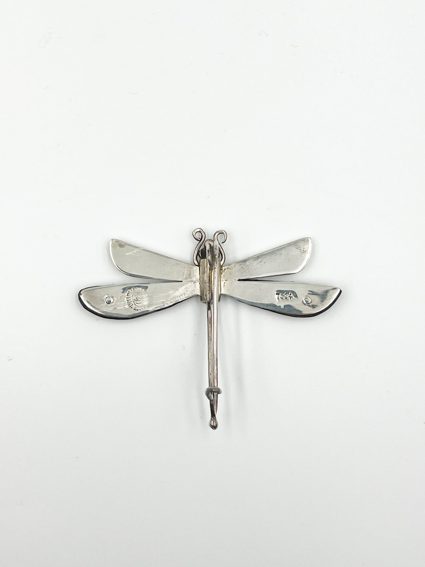 Spratling Silver and Ebony Dragonfly Pin Featuring durable black/brown Ebony wood and a playful dragonfly design, this pin is marked with the current Mexican registry mark TS-24 and an older Spratling hallmark. All items produced since 1979 by Sucesores de William Spratling are guaranteed to have these marks.