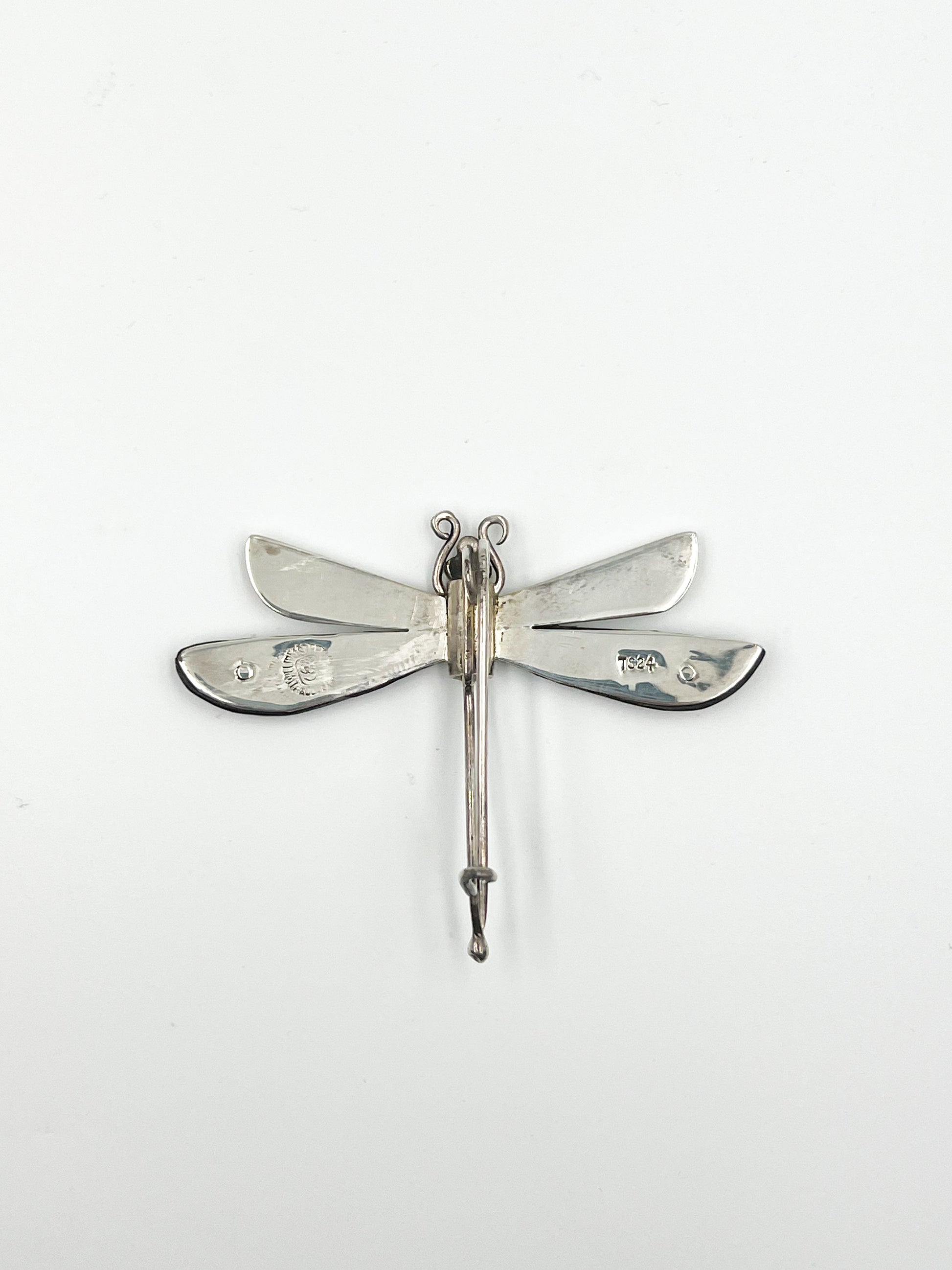 Spratling Silver and Ebony Dragonfly Pin Featuring durable black/brown Ebony wood and a playful dragonfly design, this pin is marked with the current Mexican registry mark TS-24 and an older Spratling hallmark. All items produced since 1979 by Sucesores de William Spratling are guaranteed to have these marks.